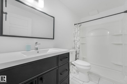 Bathroom featuring a dark wood-finish vanity with a white countertop and integrated sink - 556 Merlin Landing Landing, Edmonton, AB 