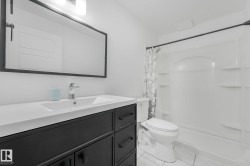 Bathroom featuring a dark wood-finish vanity with a white countertop and integrated sink - 