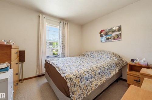 Bedroom featuring a window with natural light, neutral wall paint, and wall-to-wall carpeting - 11414 88 Street Nw, Edmonton, AB 