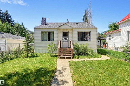 Traditional single-story residence featuring light-colored siding, a dark shingle roof, and a prominent front entryway with wooden stairs - 11414 88 Street Nw, Edmonton, AB 
