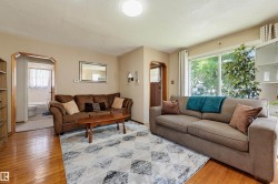 Living area featuring wood-finish flooring, neutral wall tones, and an arched entryway - 