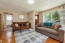 Living area featuring wood-finish flooring, neutral wall tones, and an arched entryway - 11414 88 Street Nw, Edmonton, AB 