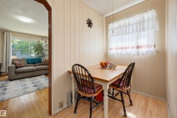 Dining area featuring wood-finish flooring and paneling, with a window providing natural illumination - 