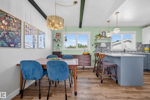 Open-concept dining area and kitchen featuring wood-finish flooring - 14128 73 Street, Edmonton, AB 