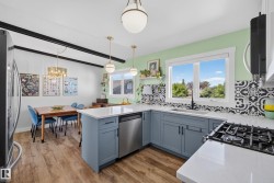 Open-concept kitchen with wood-finish flooring, light blue cabinetry, and white countertops - 