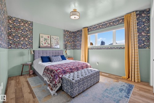 Bedroom featuring wood-finish flooring and a window with white trim - 14128 73 Street, Edmonton, AB 