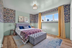 Bedroom featuring wood-finish flooring and a window with white trim - 