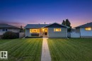 Ranch-style exterior featuring light green siding, a dark pitched roof, and a front-facing window box - 14128 73 Street, Edmonton, AB 