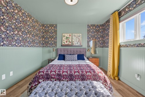 Interior room featuring wood-finish flooring, half-wall wainscoting, and patterned wallpaper - 14128 73 Street, Edmonton, AB 