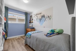 Wood-finish flooring throughout, featuring a double window with white trim, and a built-in closet system - 