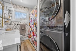 Bathroom featuring a white quartz-style countertop, a rectangular undermount sink with a matte black faucet, and patterned wallpaper - 