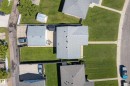Aerial view showcasing a residential property with a shingle roof and an extensive concrete patio - 14128 73 Street, Edmonton, AB 