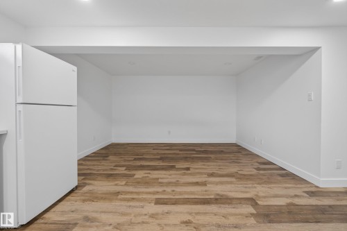 Expansive room featuring wood-finish flooring and recessed lighting - 14128 73 Street, Edmonton, AB 