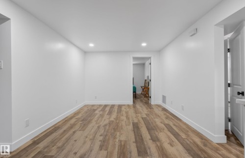 Spacious room with wood-finish flooring and recessed lighting - 14128 73 Street, Edmonton, AB 