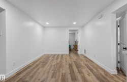 Spacious room with wood-finish flooring and recessed lighting - 