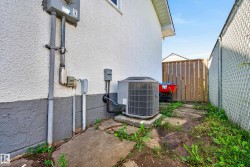 Exterior stucco siding with a painted foundation, featuring an outdoor HVAC unit on a concrete pad - 
