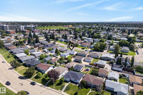 Aerial perspective showcasing a residential neighborhood with detached homes, mature trees, and visible street infrastructure - 14128 73 Street, Edmonton, AB 