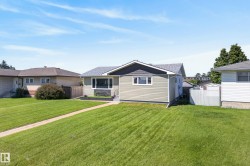 Exterior featuring light green horizontal siding and a dark gray shingle roof - 
