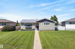 Ranch-style residence featuring light green horizontal siding and dark gray trim - 