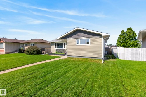 Single-story residence featuring light tan horizontal siding and dark gray shingle siding accents - 14128 73 Street, Edmonton, AB 