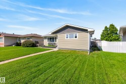 Single-story residence featuring light tan horizontal siding and dark gray shingle siding accents - 
