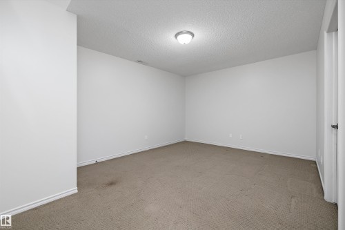 Neutral wall tones with a textured ceiling and flush mount lighting - 101 13825 155 Avenue, Edmonton, AB 