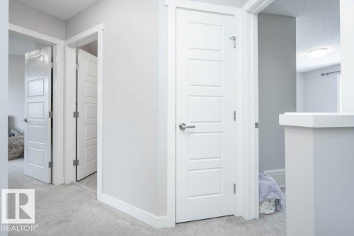 Hallway with light gray carpeting and white trim - 96 1530 Tamarack Boulevard, Edmonton, AB 