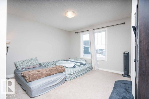 Carpeted room featuring a double window with white trim, a semi-flush mount ceiling light, and light gray wall paint - 96 1530 Tamarack Boulevard, Edmonton, AB 