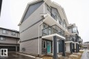 Modern multi-story facade featuring light grey siding, dark grey accent siding, and stone veneer detailing - 96 1530 Tamarack Boulevard, Edmonton, AB 