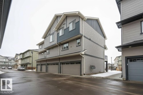 Three-story multi-unit structure featuring horizontal siding and dark trim accents - 96 1530 Tamarack Boulevard, Edmonton, AB 