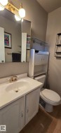 Bathroom featuring a vanity with an integrated sink, gold-toned faucet, and storage cabinet below - 