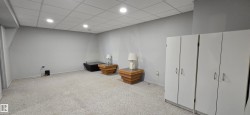 Spacious room featuring light gray walls, light-colored carpet flooring, recessed lighting, and a drop ceiling - 