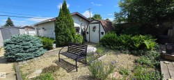 Landscaped backyard featuring a gravel path and a black metal bench - 