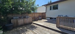 Expansive multi-level wood deck featuring a built-in outdoor storage unit - 