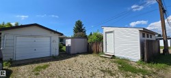 Attached single-car garage featuring a white overhead door and white siding - 