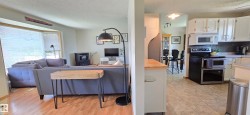 Kitchen featuring white cabinetry, stainless steel appliances, and a tiled floor - 