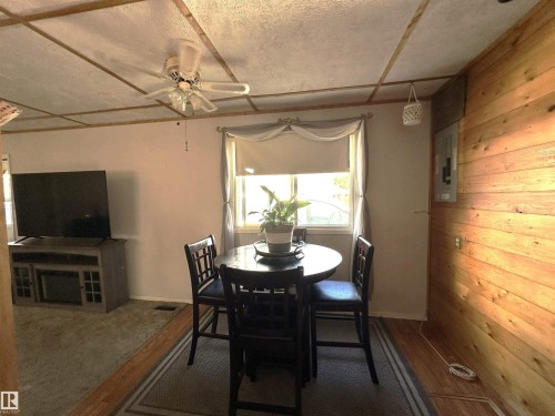 Interior space featuring wood-finish flooring, a ceiling fan, and a window with blinds - 825 2 Street, Thorhild, AB 