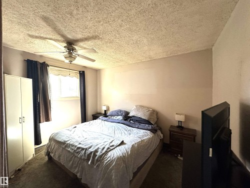 Room featuring textured ceiling, neutral wall tones, and carpet flooring - 825 2 Street, Thorhild, AB 