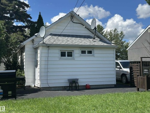 White siding exterior with a pitched roof and multiple windows - 825 2 Street, Thorhild, AB 