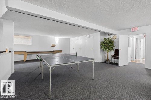 Spacious recreation room featuring dark gray carpeting and recessed lighting - 219 Knottwood Road, Edmonton, AB 