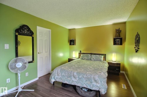 Bedroom featuring wood-finish flooring, a paneled door, and baseboard trim - 30 14620 26 Street, Edmonton, AB 