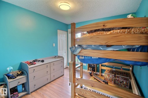 Room featuring wood-finish flooring, a paneled door, and a flush-mount ceiling light - 30 14620 26 Street, Edmonton, AB 