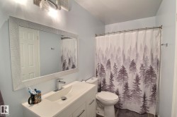 Modern vanity featuring an integrated sink with a chrome faucet, under-sink cabinetry, and a large framed mirror - 