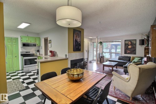 Open-concept living area featuring a kitchen with checkered flooring, a breakfast bar, and light green cabinetry - 30 14620 26 Street, Edmonton, AB 
