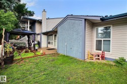 Expansive backyard featuring a lush lawn, a covered deck with a dark-framed gazebo, and a concrete patio - 