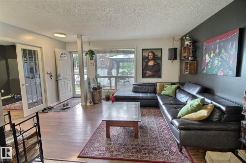 Open-concept living space with wood-finish flooring extending throughout - 30 14620 26 Street, Edmonton, AB 