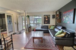 Open-concept living space with wood-finish flooring extending throughout - 