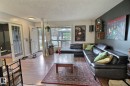 Open-concept living space with wood-finish flooring extending throughout - 30 14620 26 Street, Edmonton, AB 