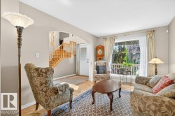 Living area featuring wood-finish flooring, a large picture window, and neutral wall tones - 