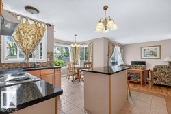 Kitchen featuring an electric range, granite-style countertops, wood-finish cabinetry, and a tiled backsplash - 